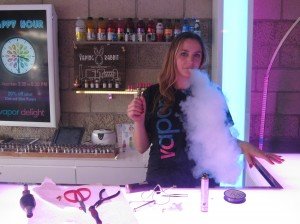 Vapor Delight sales associate Michelle Sapio demonstrates how to use an electronic cigarette.