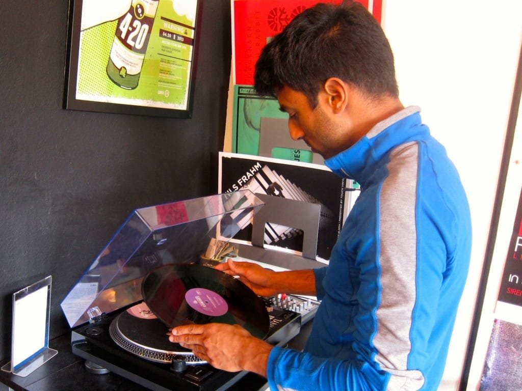 At the boutique record store Touch Vinyl in West Los Angeles, owner Sebastian Matthews gives a listen to one of the many new vinyl recordings in stock. (Photos by Saul Rubin)