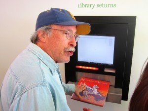 Gene Oppenheim, a member of Santa Monica’s Library Board, returns books at the Pico Branch’s automated system on Saturday.