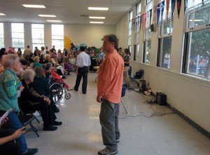 SMRR co-founder and candidate campaign manager Denny Zane stands in front of the crowd at John Adams Middle School Sunday.