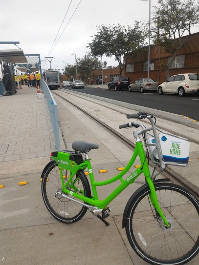 A "Breeze" bike-share bike with an Expo test train in the background at the future 17th Street station. Santa Monica's bike-share system is set to launch city-wide later this year.